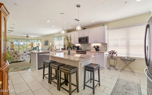 a kitchen with stainless steel appliances kitchen island granite countertop a sink and cabinets