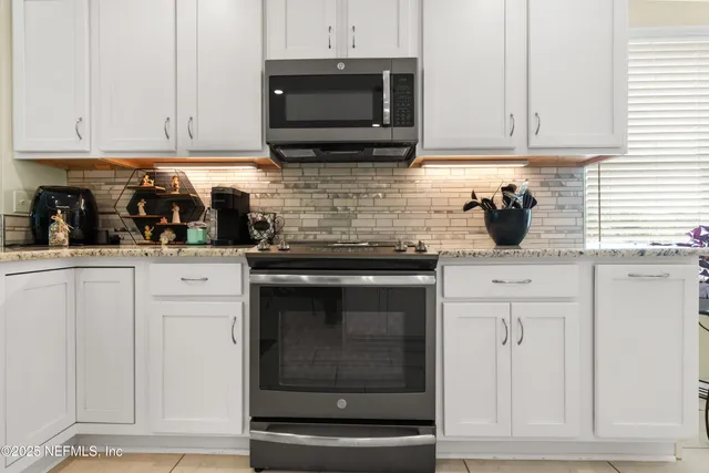 a kitchen with stainless steel appliances granite countertop a stove and cabinets