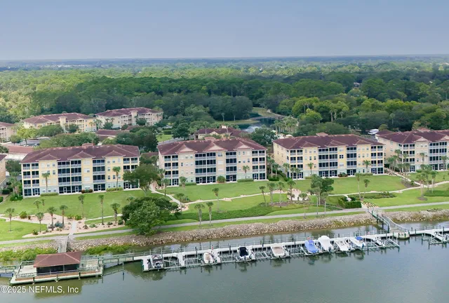 an aerial view of a house with a garden and lake view