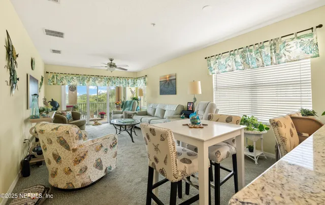 a living room with furniture and a floor to ceiling window