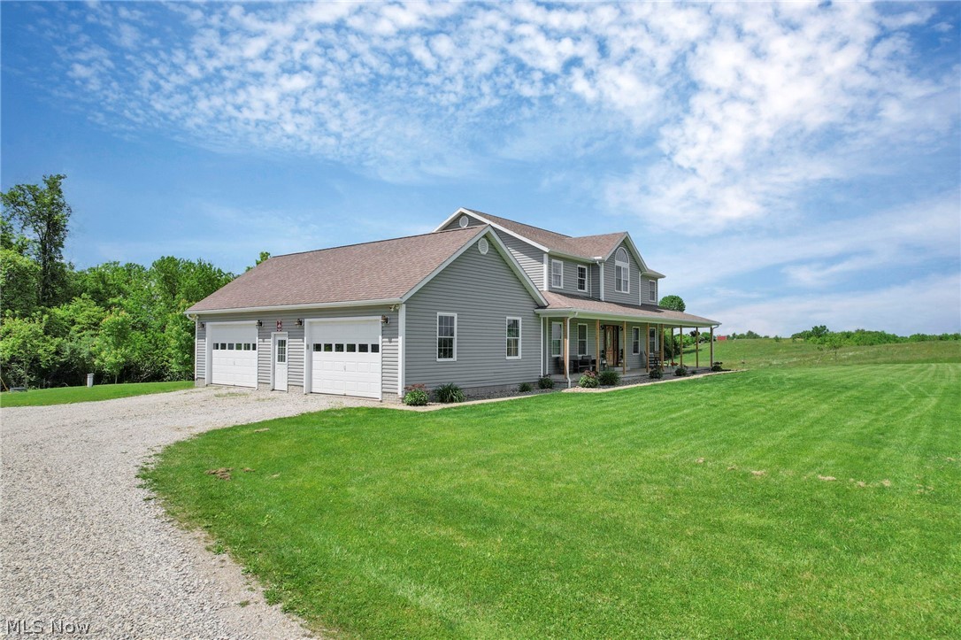 3483 Cooper Road Cumberland, OH 43732 - Photo 40 of 50 View of front of property featuring a front lawn, a garage, and a porch