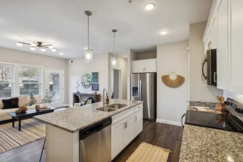 a kitchen with stainless steel appliances granite countertop a sink a stove and a refrigerator