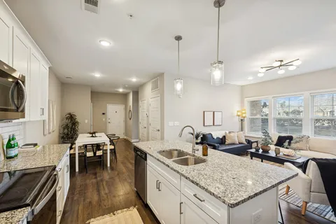 a kitchen with center island a sink stainless steel appliances and living room view