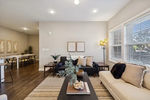 a living room with furniture a rug and a table