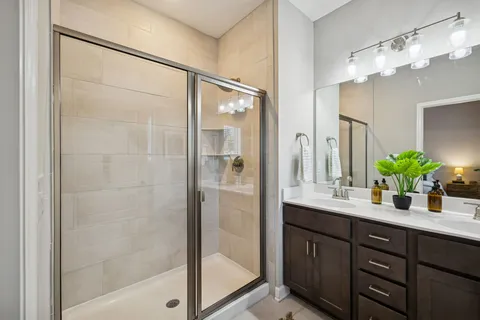 a bathroom with a double vanity sink mirror and shower