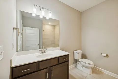 a bathroom with a sink a toilet a mirror and shower