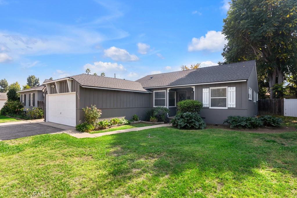 a view of a house with a yard and pathway