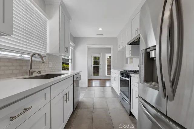 a large kitchen with a sink and refrigerator