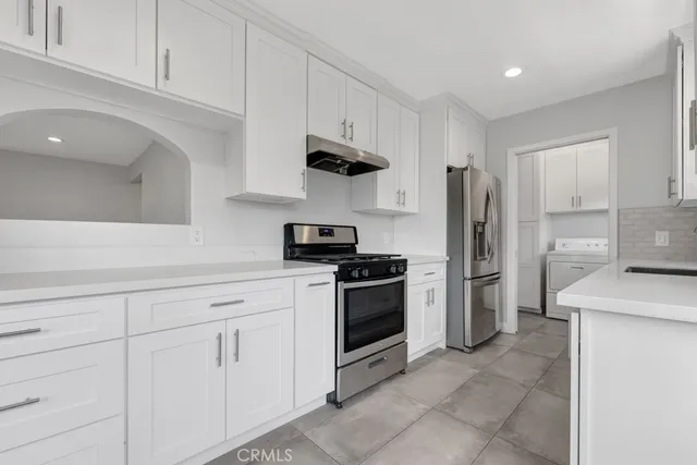 a kitchen with stainless steel appliances granite countertop a refrigerator sink and stove