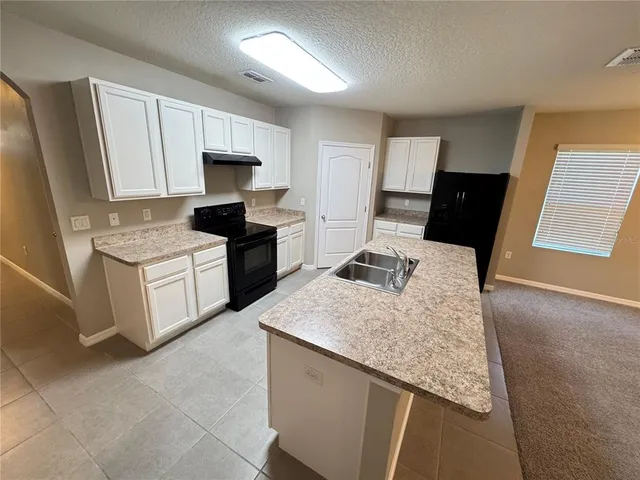 a view of a kitchen with a sink and cabinets