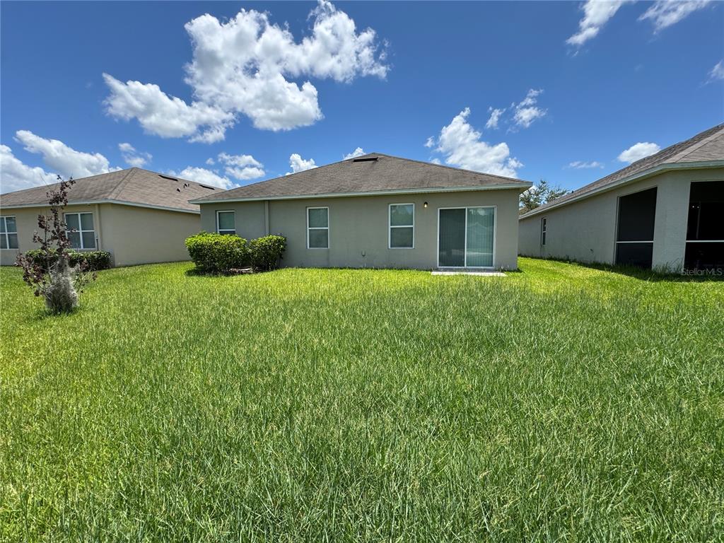 2323 Silverview Drive Lakeland, FL 33811 - Photo 32 of 33 a white house with a big yard and potted plants in front of it