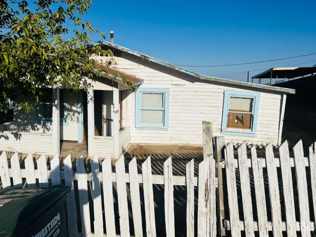 a front view of a house with wooden fence