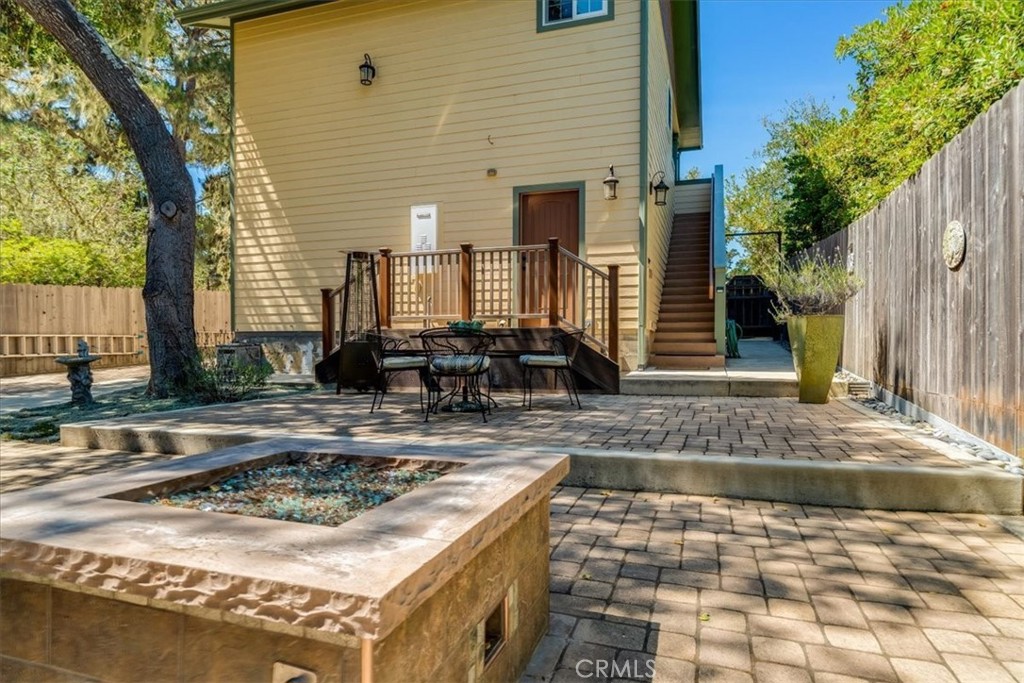 1560 Emerson Road Cambria, CA 93428 - Photo 13 of 13 The back entrance of the garage, where you will access the laundry facilities. The patio furniture and the stairs to the front entrance of the studio. The street entrance is at the gate to the right of the stairs.