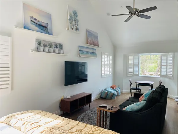 a living room with furniture a flat screen tv and a window