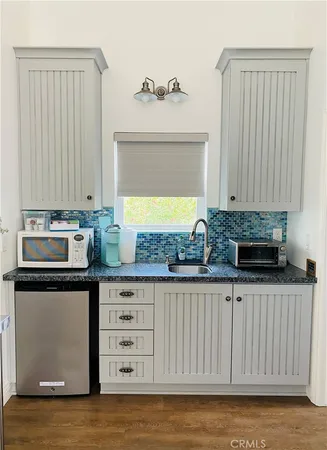 a kitchen with granite countertop white cabinets and sink