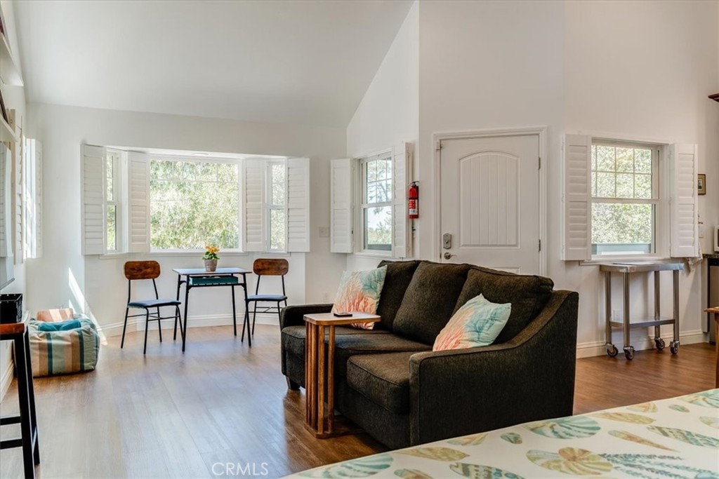 1560 Emerson Road Cambria, CA 93428 - Photo 8 of 13 Living, dining and entry door. This studio is very spacious, with vaulted ceilings to create a very open space. Plantation shutters all around, to bring the outdoors in.