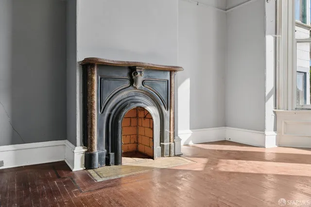 a view of a livingroom with a fireplace wooden floor and window