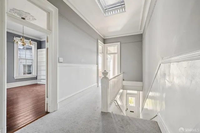 a view of a small space with wooden floor and a window