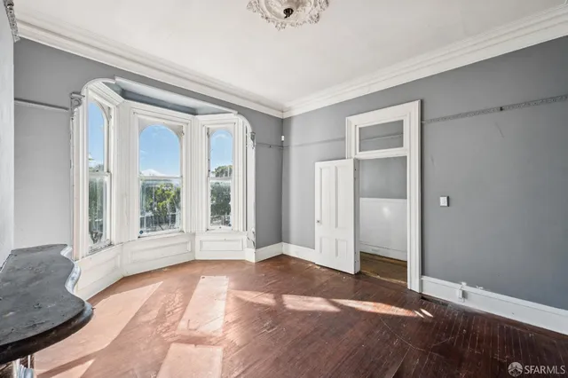 a view of a hallway with wooden floor and a chandelier