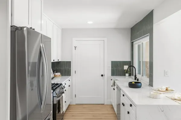 a kitchen with stainless steel appliances a refrigerator sink and stove