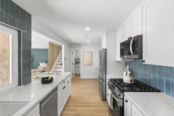 a kitchen with kitchen island stainless steel appliances a sink stove and refrigerator