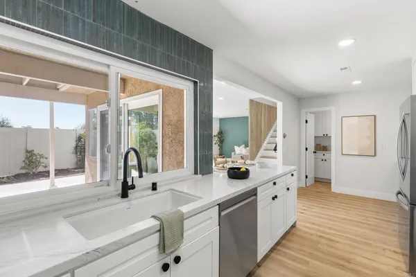 a large white kitchen with a large window