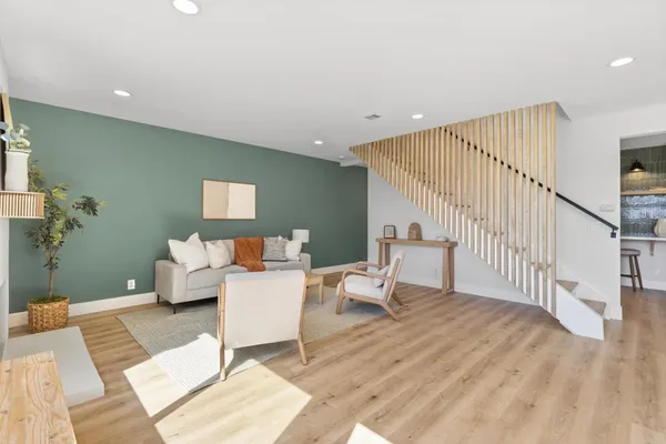 a living room with furniture mirror and a wooden floor