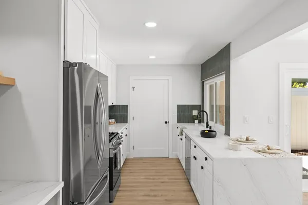 a large white kitchen with a large window