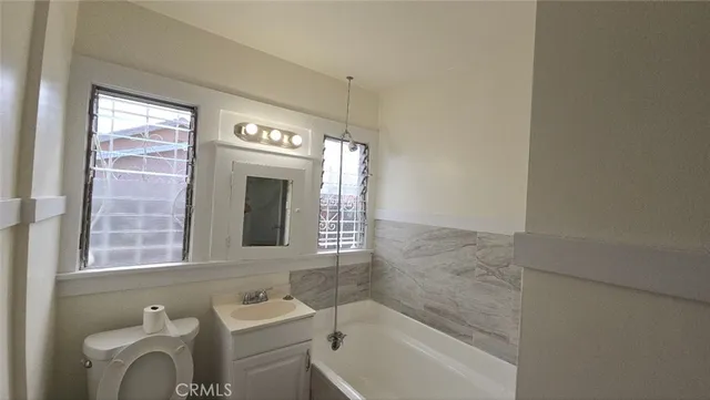 a bathroom with a sink toilet a mirror and bathtub