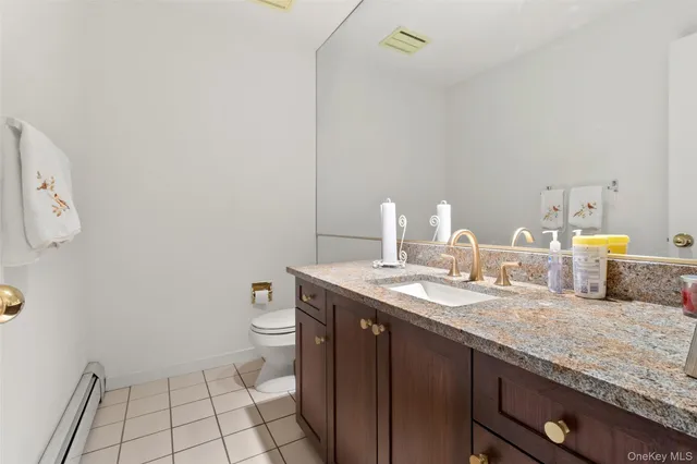 a bathroom with a granite countertop sink a toilet and a mirror