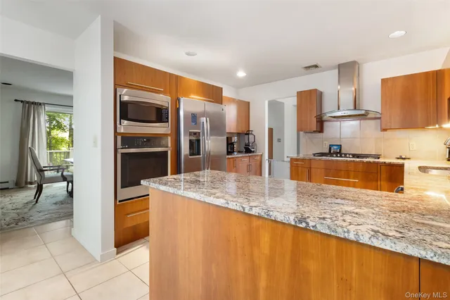 a kitchen with stainless steel appliances granite countertop a sink and a refrigerator