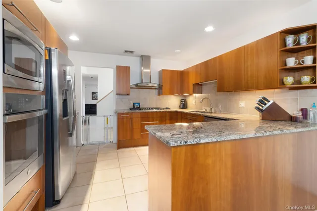 a kitchen with stainless steel appliances granite countertop a sink and a refrigerator