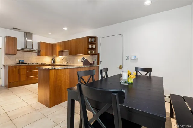 a kitchen with a dining table chairs and refrigerator