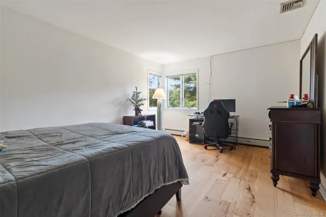 a bedroom with a bed and dresser with mirror