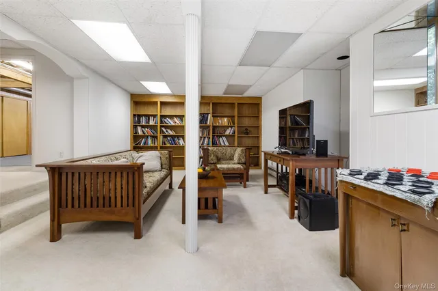 a living room with furniture and a book shelf
