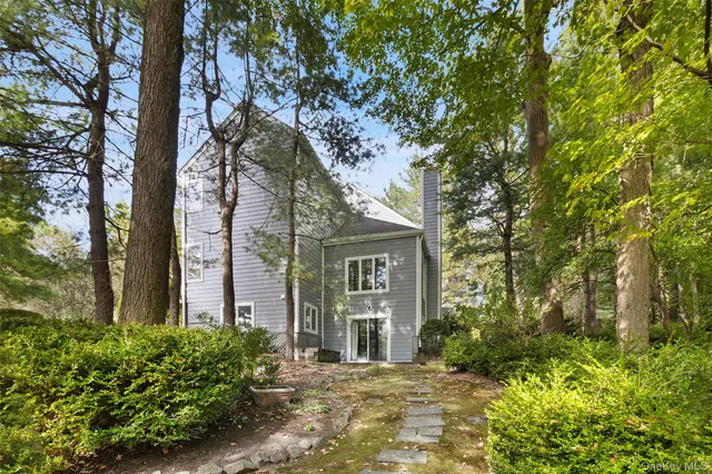 a front view of a house with a tree