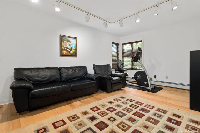 a living room with a couch and a dresser with wooden floor