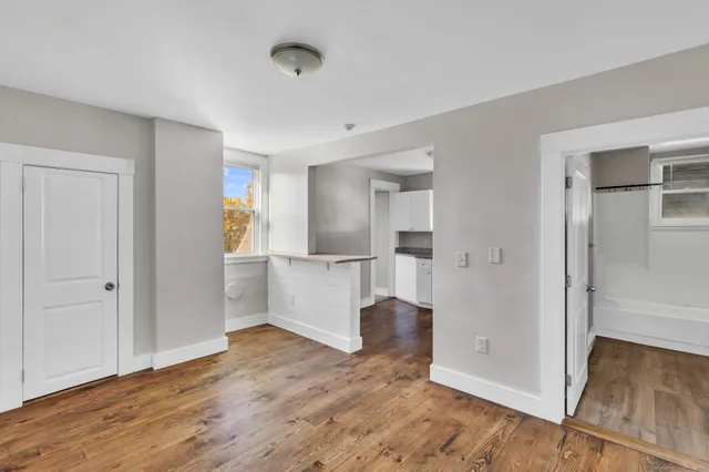 a view of empty room with wooden floor