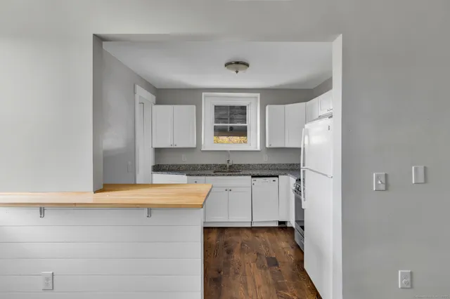 a kitchen with granite countertop a sink and a stove top oven