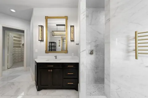 a bathroom with a granite countertop sink a mirror and shower