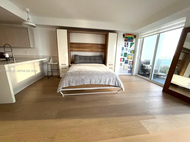 a bedroom with a bed and a large window