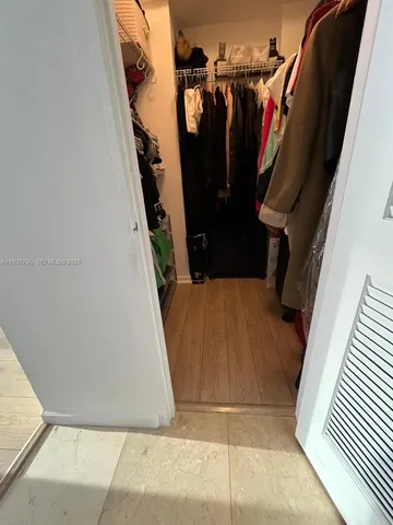 a view of walk in closet with clothes and shoes