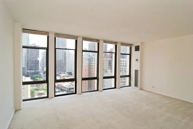 an empty room with windows and city view