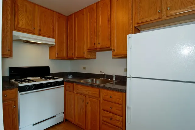 a kitchen with stainless steel appliances granite countertop white refrigerator stove a sink and dishwasher