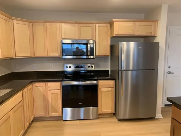 a view of a livingroom and a kitchen with wooden floor