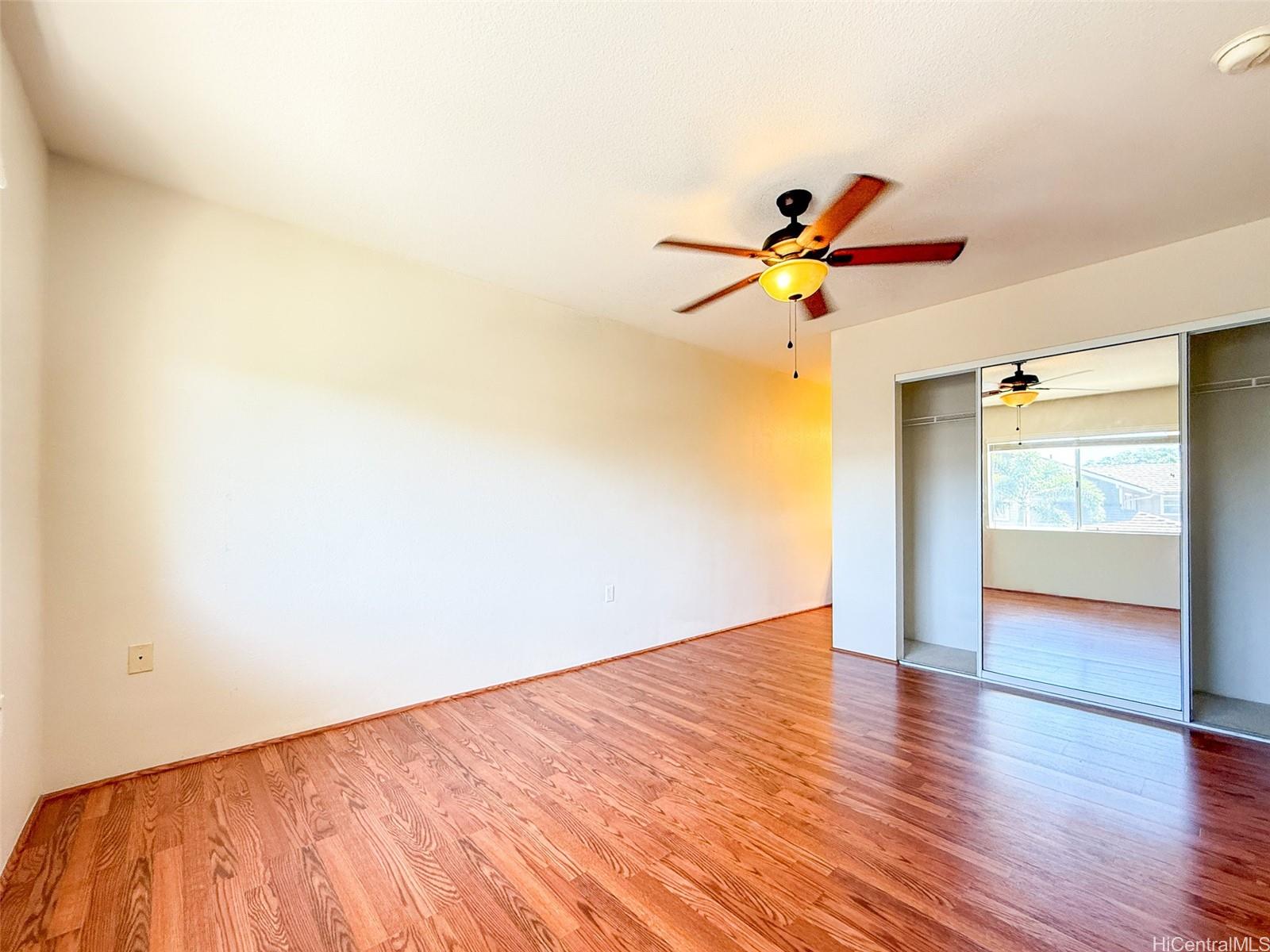 92-1519 Ali'inui Drive, Unit 12A Kapolei, HI 96707 - Photo 25 of 25 a view of a room with wooden floor and a chandelier fan