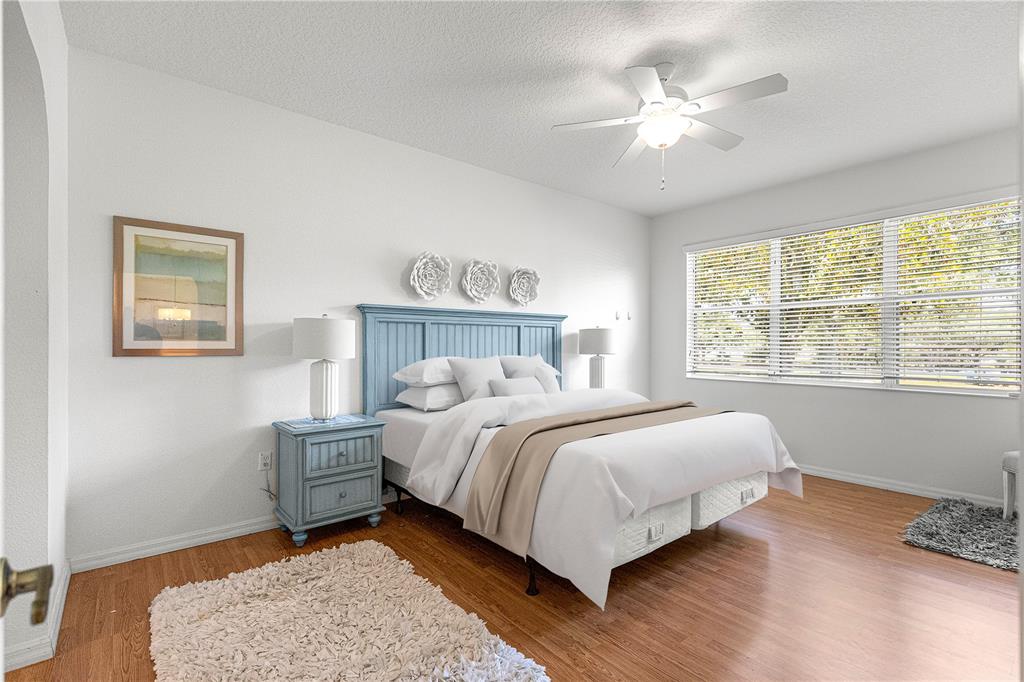 9317 Southwest 94th Loop Ocala, FL 34481 - Photo 16 of 40 a bedroom with a bed chandelier and a window