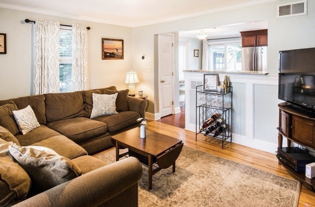 69 Keystone Street, Unit 1 Boston, MA 02132 - Photo 4 of 10 a living room with furniture a flat screen tv and a refrigerator