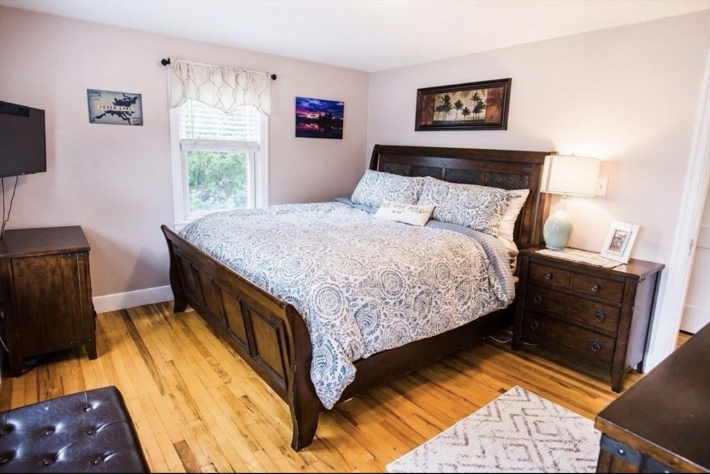 69 Keystone Street, Unit 1 Boston, MA 02132 - Photo 6 of 10 a bedroom with a bed and a flat screen tv