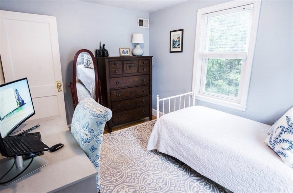 69 Keystone Street, Unit 1 Boston, MA 02132 - Photo 7 of 10 a bed sitting in a bedroom next to a window